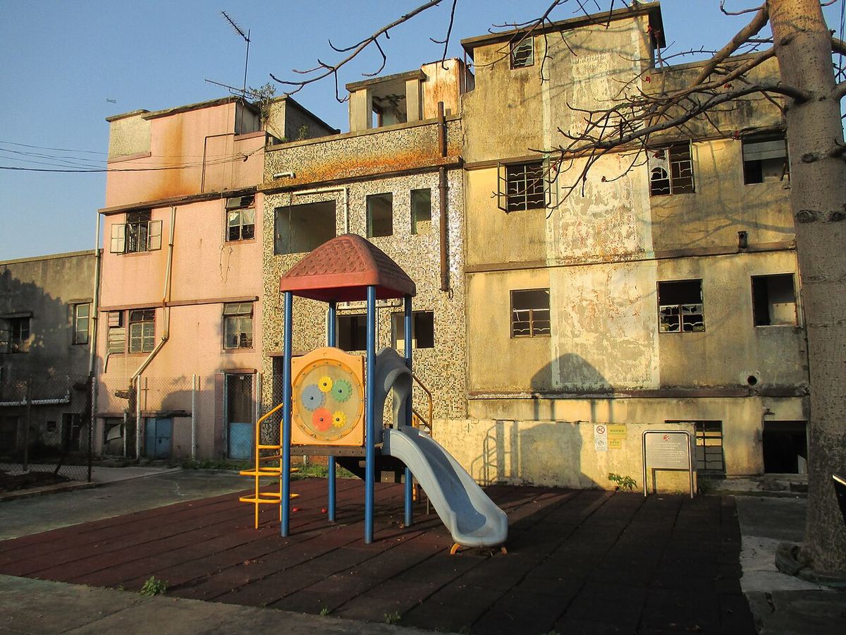 Loc de joacă pentru copii, cu echipamente colorate, fotografiat în aer liber.