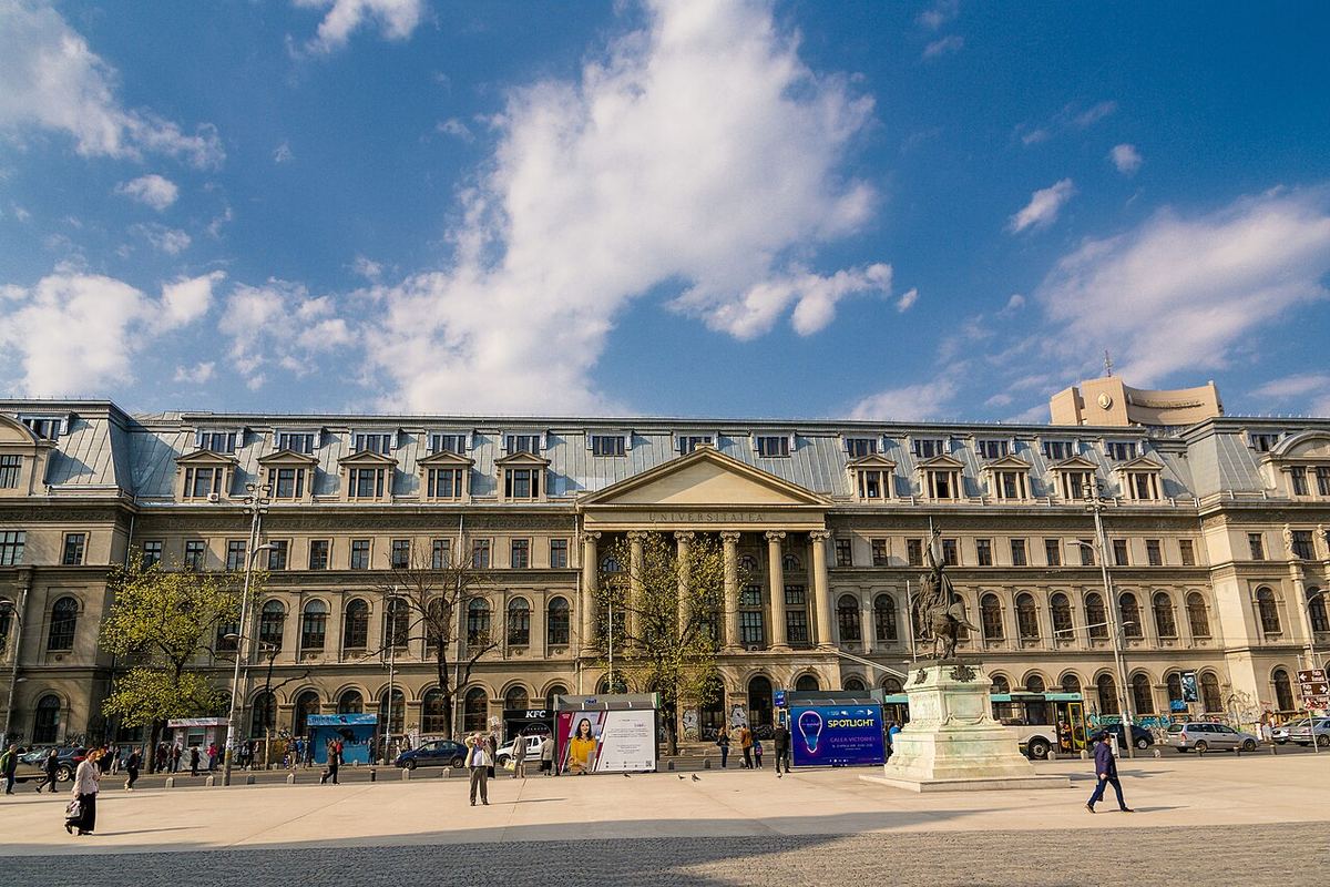 Fațada Palatului Universității din București, în lumina zilei, cu coloane și statui în față.