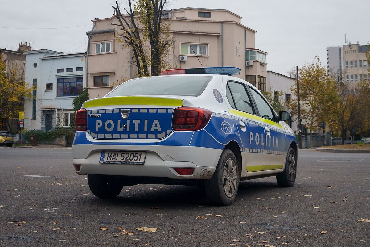Autoturism Dacia Logan al Poliției Române, în livrea albastru-galben, ilustrație pentru știrea despre reținerea a patru tineri.