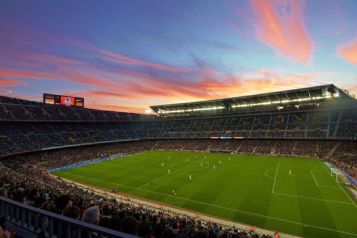 Imagine a unui stadion mare de fotbal, cu tribunele înconjurând terenul.