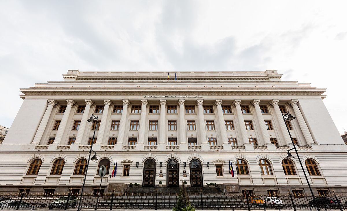 Sediul Băncii Naționale a României din București, fotografiat din fața clădirii, cu coloane albe și ferestre arcuite.