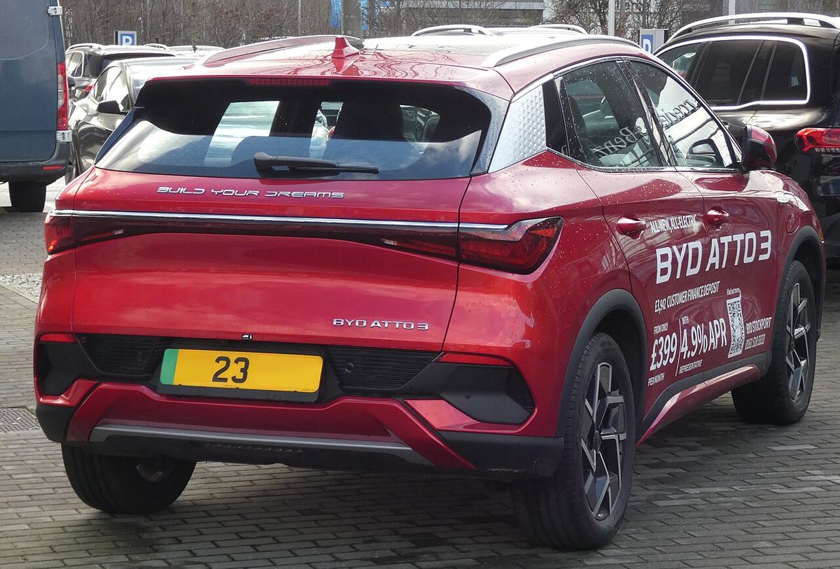 Autoturism electric BYD Atto 3 roșu, fotografiat din spate, parcat pe o alee. Imagine ilustrativă.