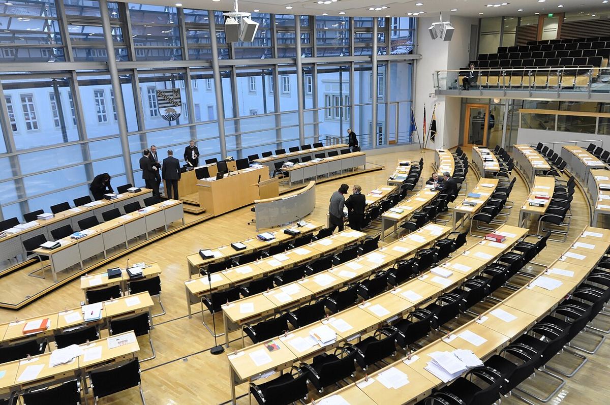 Sala plenară a Landtagului Saxoniei-Anhalt din Magdeburg, cu rânduri de bănci și pupitre pentru deputați.