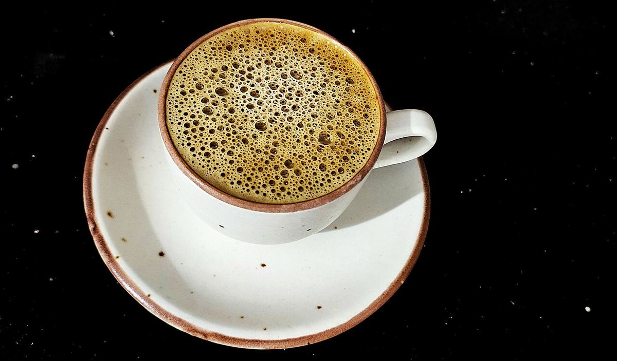 Ceașcă de cafea cu farfurioară, fotografiată de sus sau din lateral.