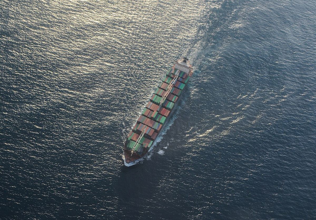 Fotografie aeriană a unei nave de marfă pe mare, văzută de sus.