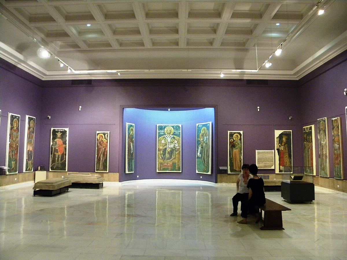 Sală de expoziție într-un muzeu de artă, cu tablouri pe pereți