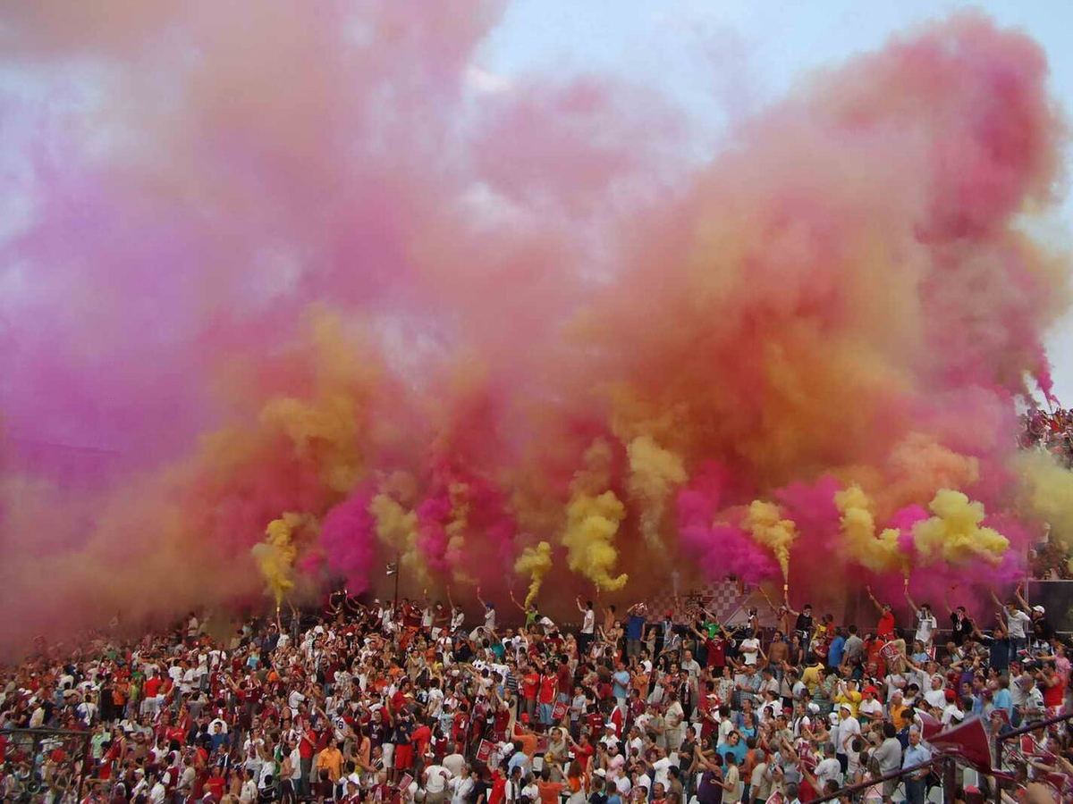 Suporteri ai echipei de fotbal CFR Cluj, fotografiați în timpul unui meci.