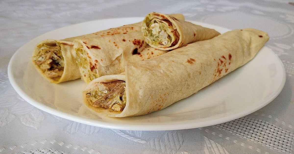 Burrito chihuahuense casero cu chile verde, un preparat mexican servit pe o farfurie.