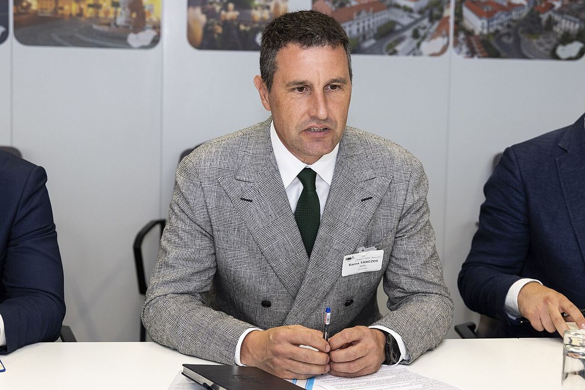 Barna Tánczos, ministrul interimar al Agriculturii, la o întâlnire oficială, în costum gri și cravată verde.
