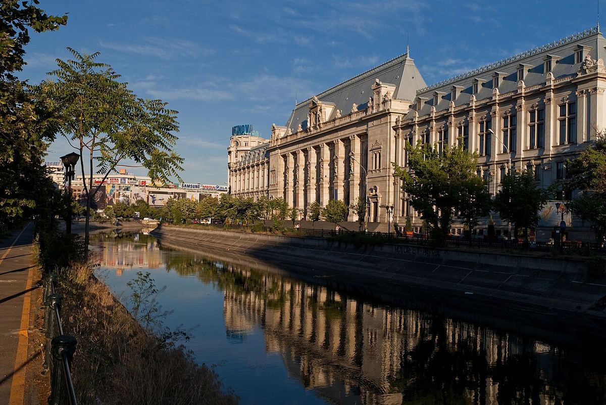 Palatul Justiției din București, fotografiat la apus, cu fațada principală văzută de-a lungul canalului.