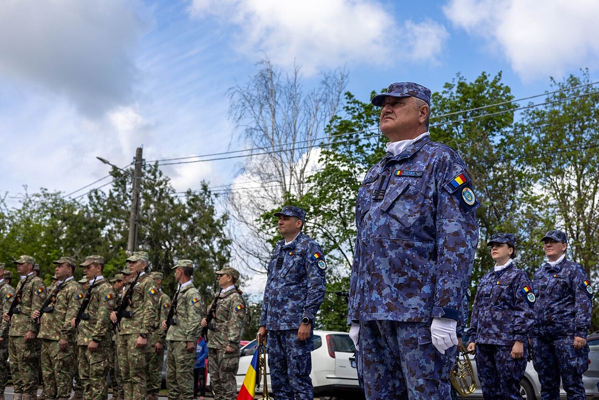 Fanfara militară română stă la atenție în timpul unei ceremonii de dezvelire a unui monument la Topraisar, Constanța.
