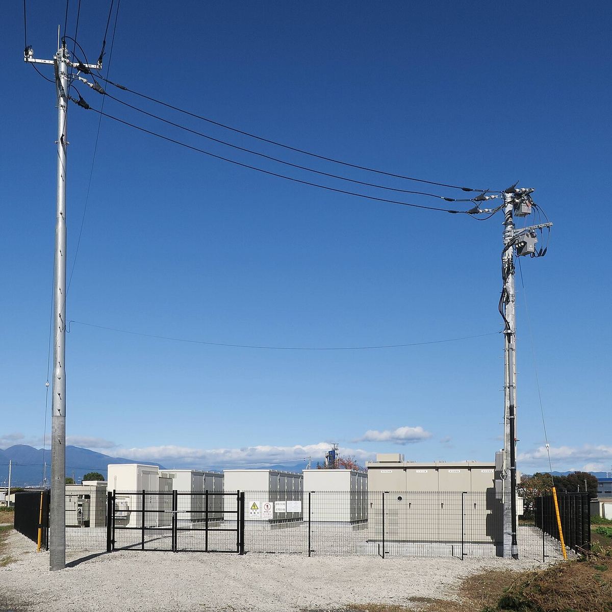 Instalație de stocare a energiei în baterii, cu containere și echipamente electrice amplasate în exterior.