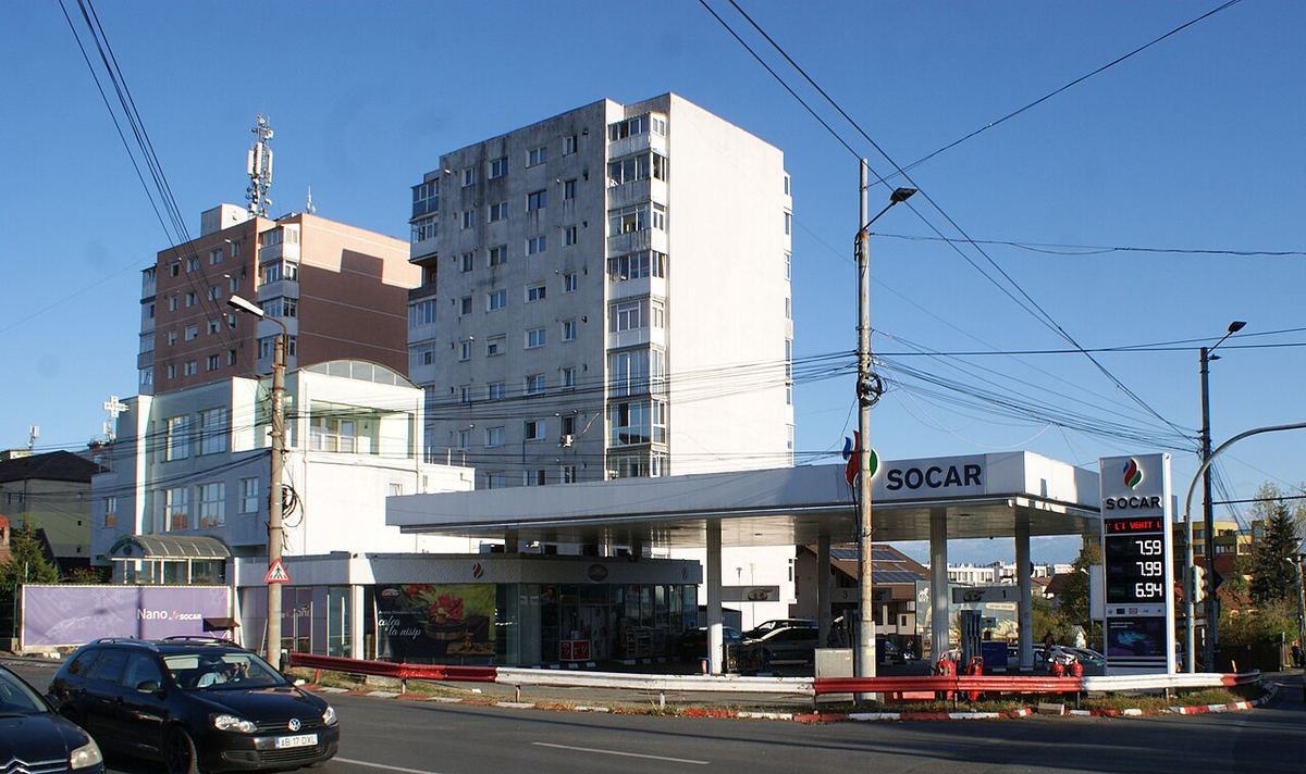 Benzinărie la marginea unui oraș, cu blocuri în fundal