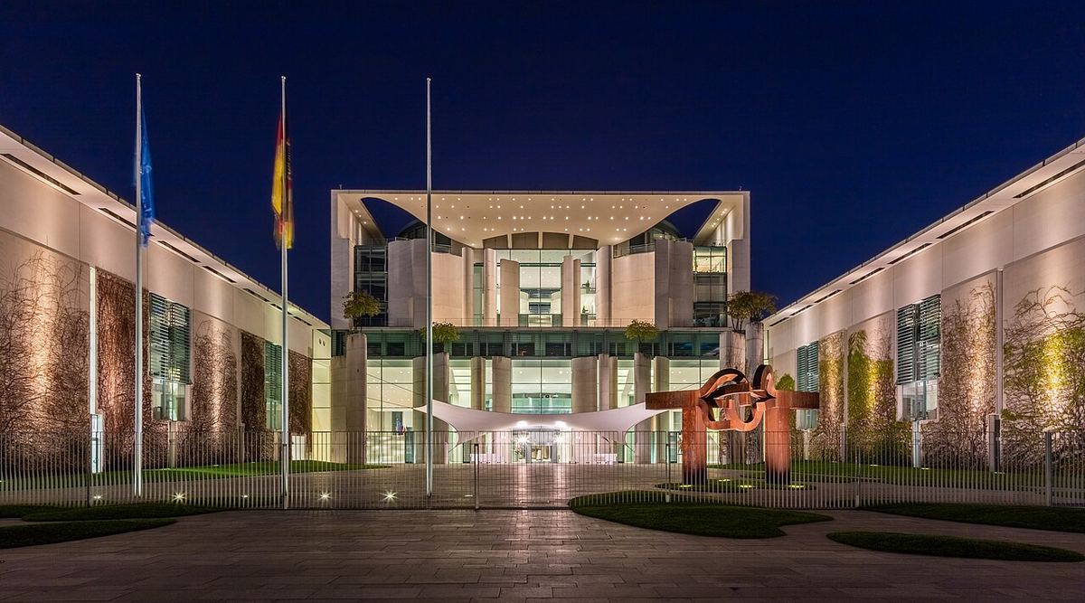 Clădirea Cancelariei Federale a Germaniei din Berlin, fotografiată noaptea, cu fața principală iluminată.