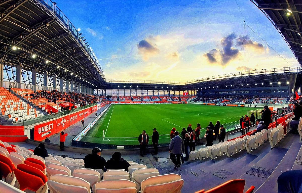 Tribunele și terenul stadionului Sepsi OSK din Sfântu Gheorghe, cu publicitate Unibet, fotografiat în timpul unui meci.