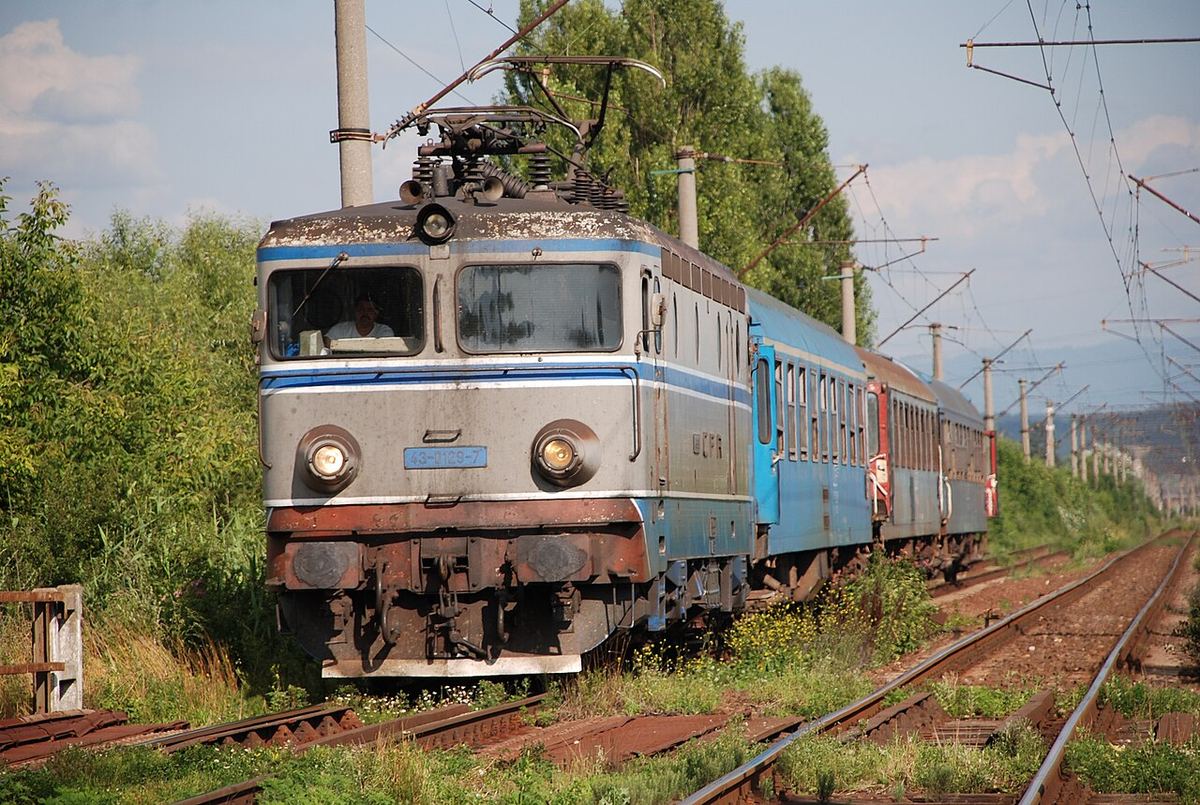 Locomotivă electrică CFR Călători trăgând un tren de călători pe o linie feroviară din România, fotografie de arhivă.
