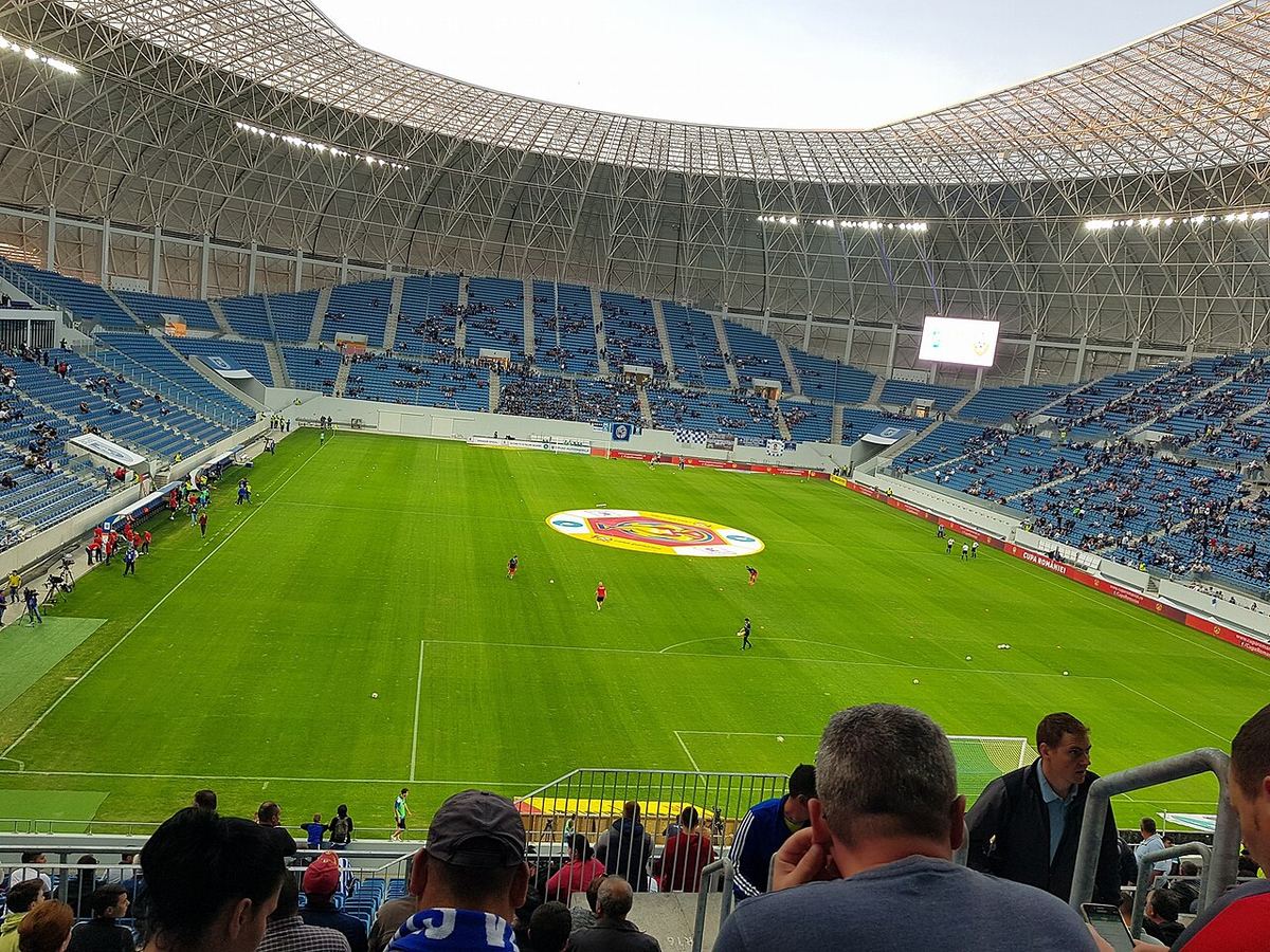 Vedere generală a stadionului Ion Oblemenco din Craiova, cu gazonul verde și tribunele goale, înaintea unui meci de fotbal.