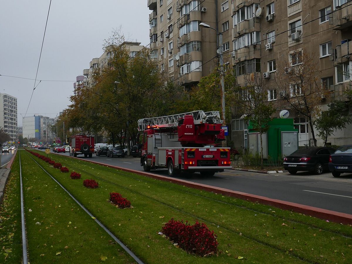 Autospeciale de pompieri care răspund la o urgență pe un bulevard
