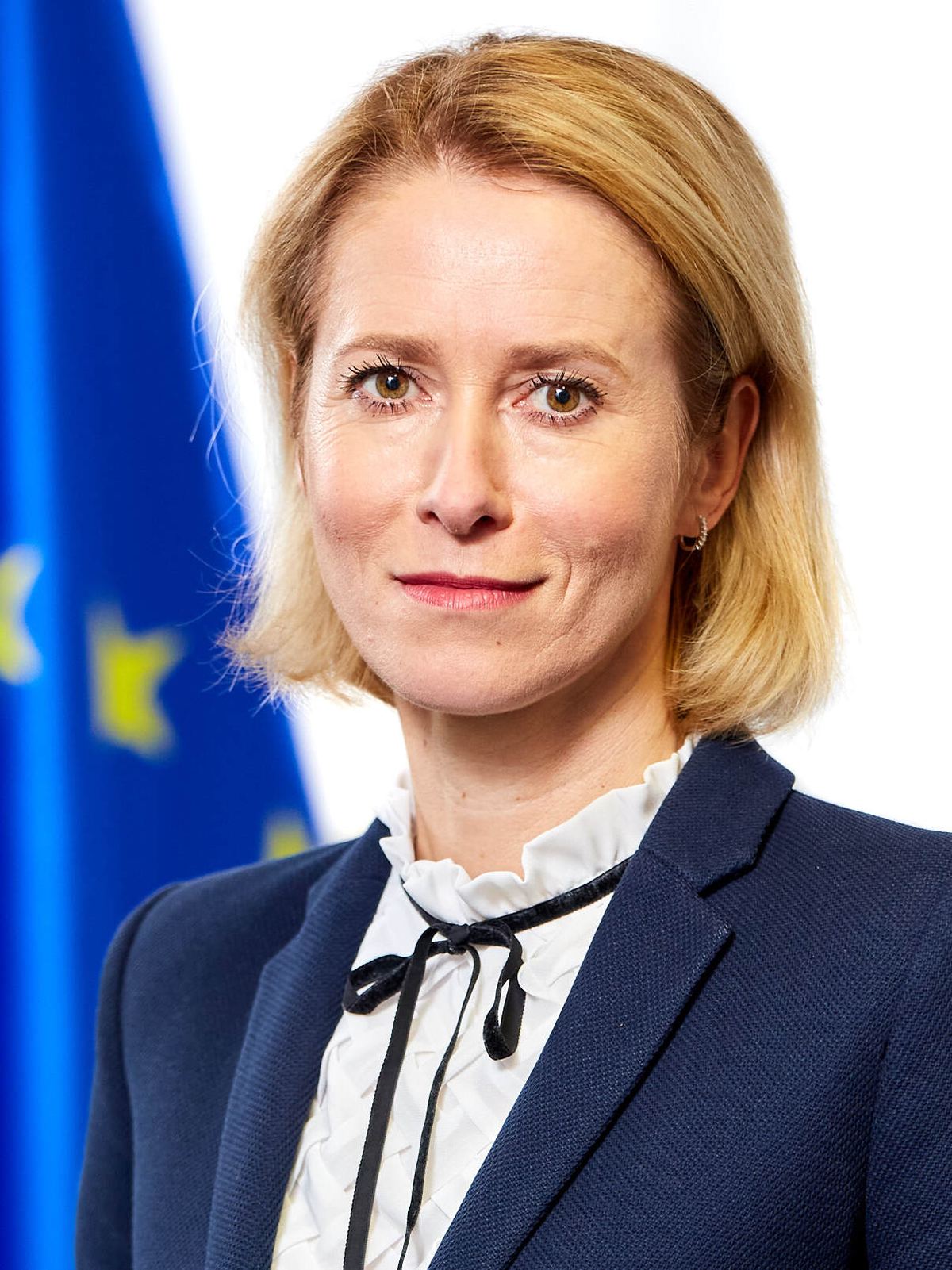 Portretul Kajei Kallas, înaltă reprezentantă a Uniunii Europene pentru afaceri externe, în fața unui steag al UE.