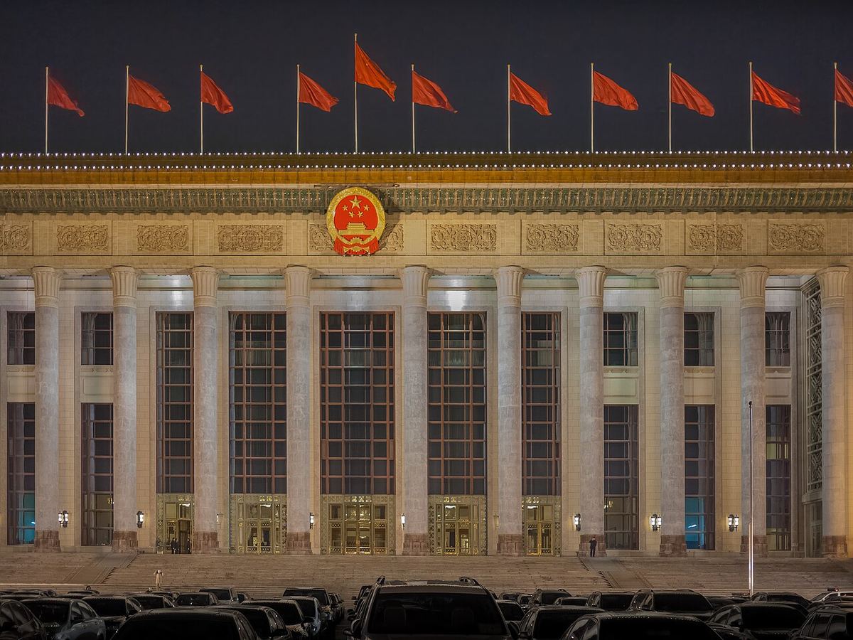 Marea Sală a Poporului din Beijing, iluminată noaptea, cu fațada sa monumentală în prim-plan.
