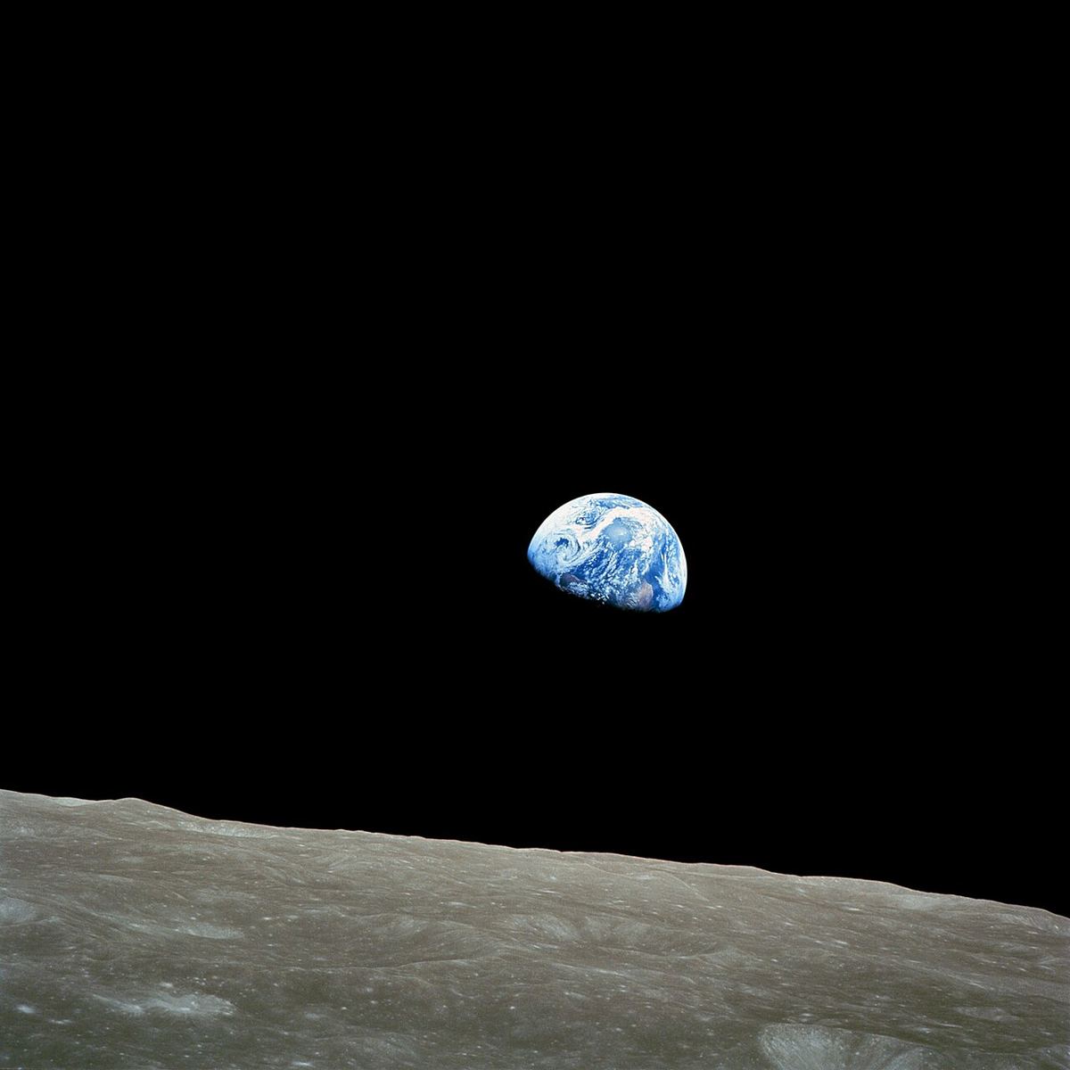 Fotografie NASA din 1968: Pământul răsărind deasupra orizontului Lunii, văzut de pe orbita lunară, pe fundal negru.