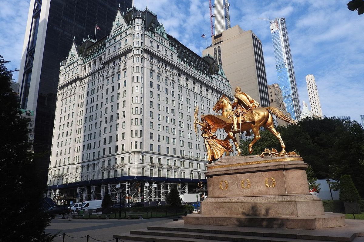 Fațada hotelului The Plaza din New York, cu statuia equestră aurie a generalului Sherman în prim-plan, ziua.