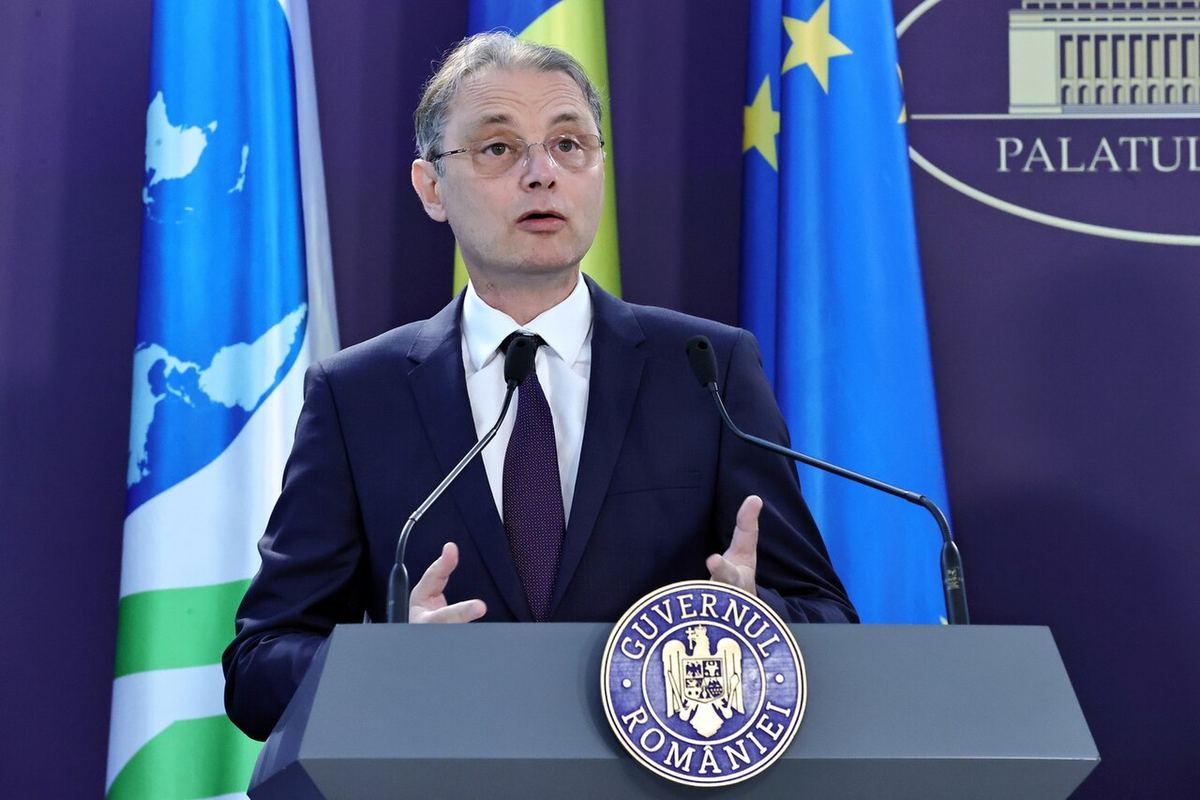 Luca Niculescu vorbește la pupitrul cu sigla Guvernului României, în fața steagului UE (fotografie de arhivă, 2022).