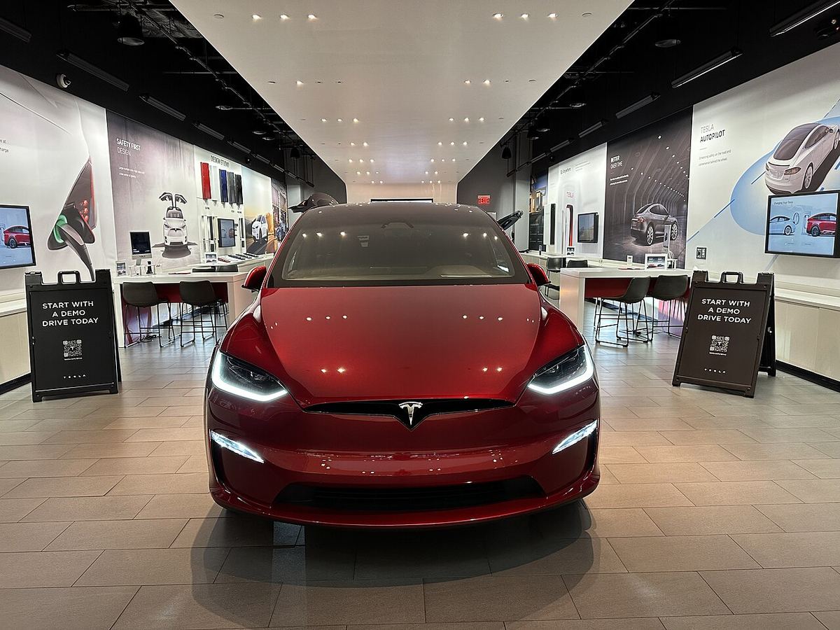 Un autoturism roșu expus într-un showroom, imagine ilustrativă legată de subiectul vehiculelor Tesla.