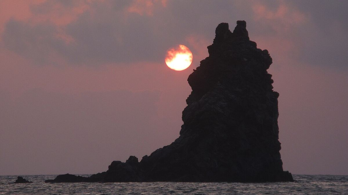 Apus peste Scoglio delle Sirene, o stâncă din apropierea insulei Vulcano, în Sicilia, Italia.