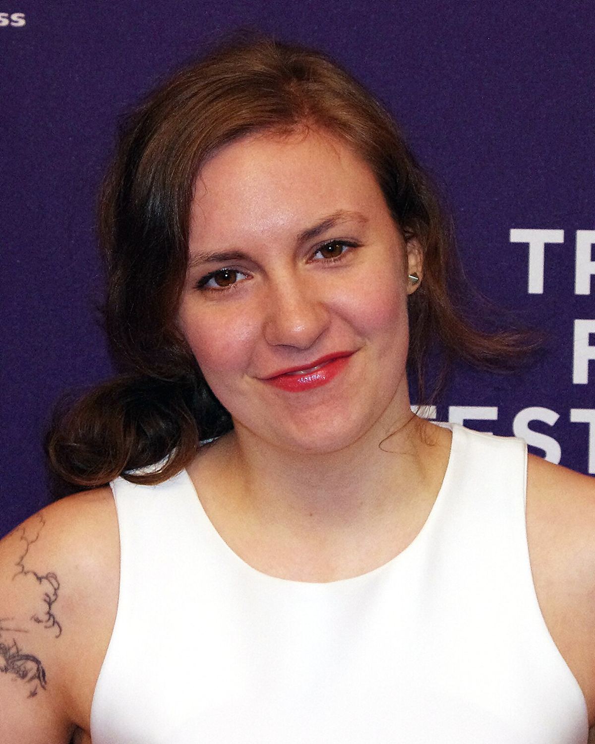 Lena Dunham la Festivalul de Film Tribeca 2012, în fața unui fundal violet (fotografie de arhivă).