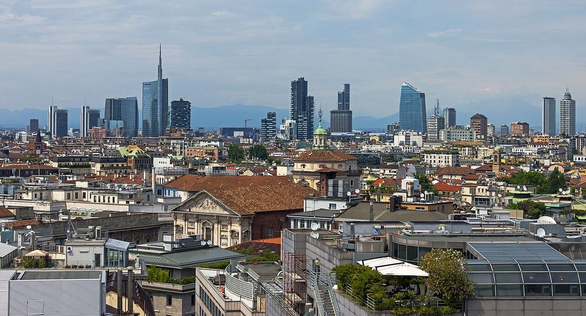 Panorama orașului Milano, văzută de pe acoperișul Domului, cu clădiri dense sub cerul luminos.
