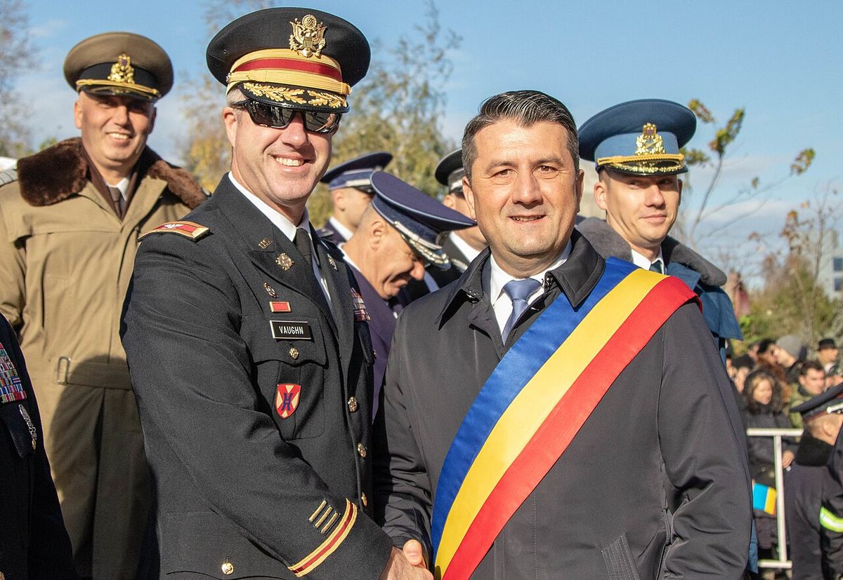 Un ofițer militar american strânge mâna unui oficial civil în timpul paradei de Ziua Unirii din Constanța.