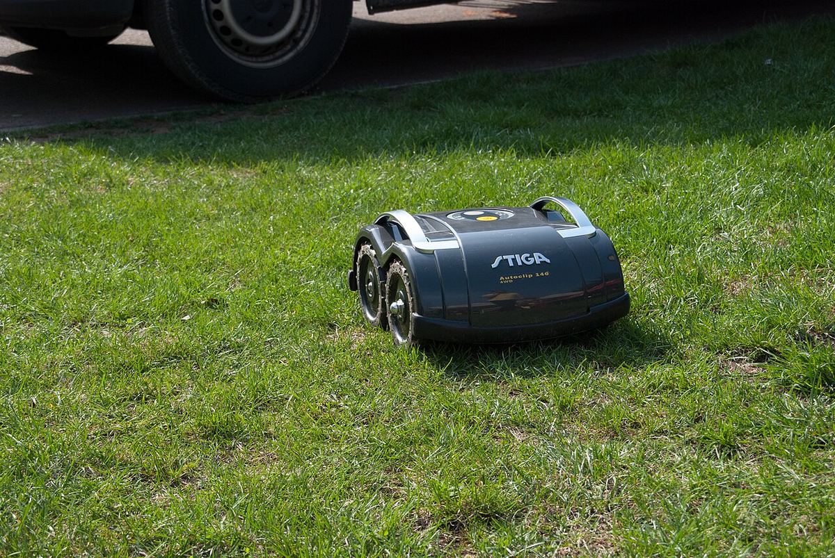 Robot de tuns iarba Stiga AutoClip 140 pe o pajiște verde.