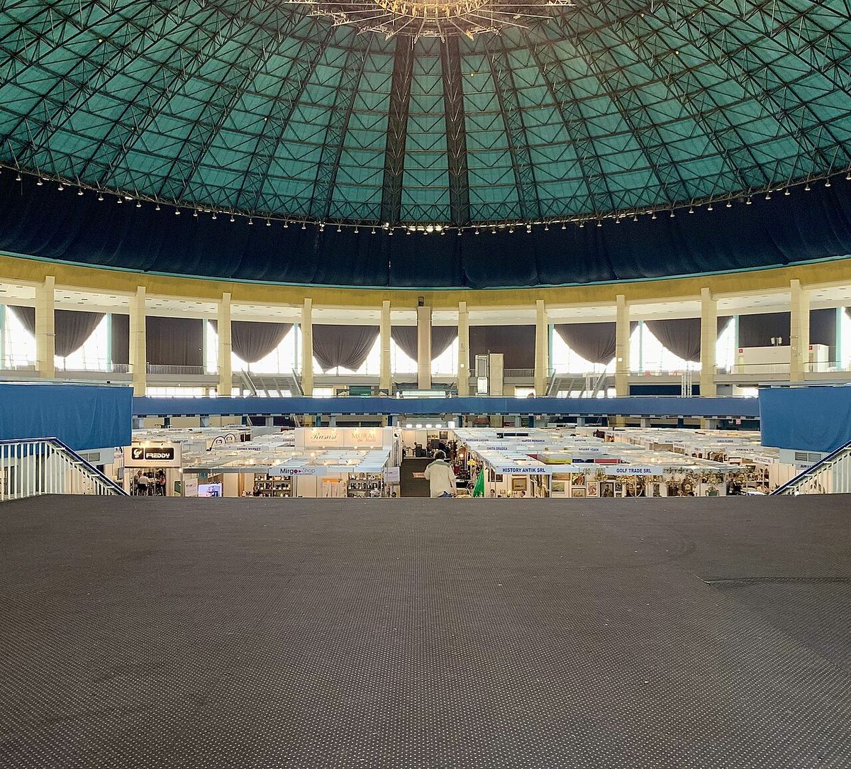 Interiorul unui pavilion central de expoziții, cu spații largi și structură deschisă, ilustrativ pentru un eveniment.