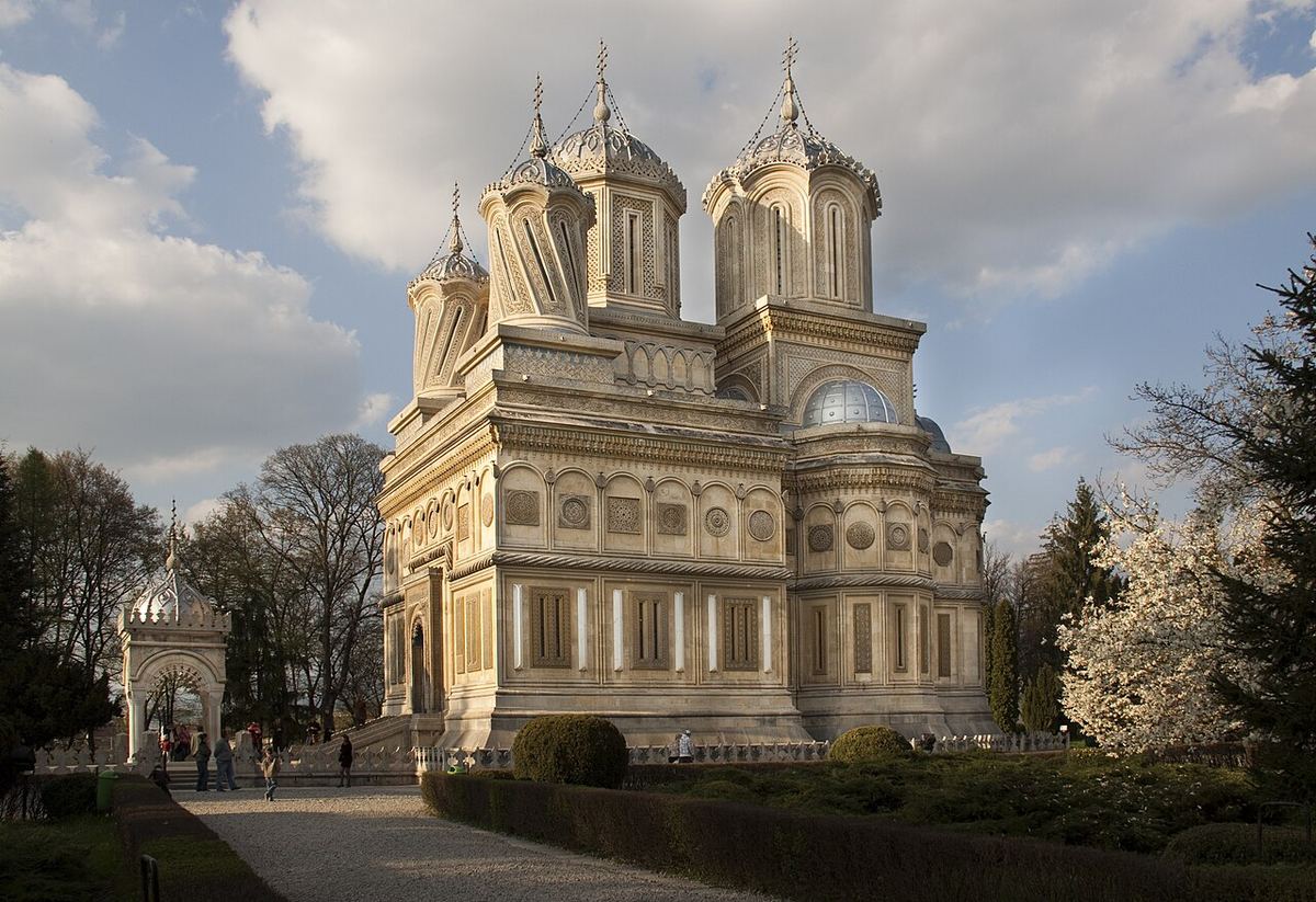 Vedere exterioară a Mănăstirii Curtea de Argeș, din România, cu arhitectura sa tradițională de piatră.