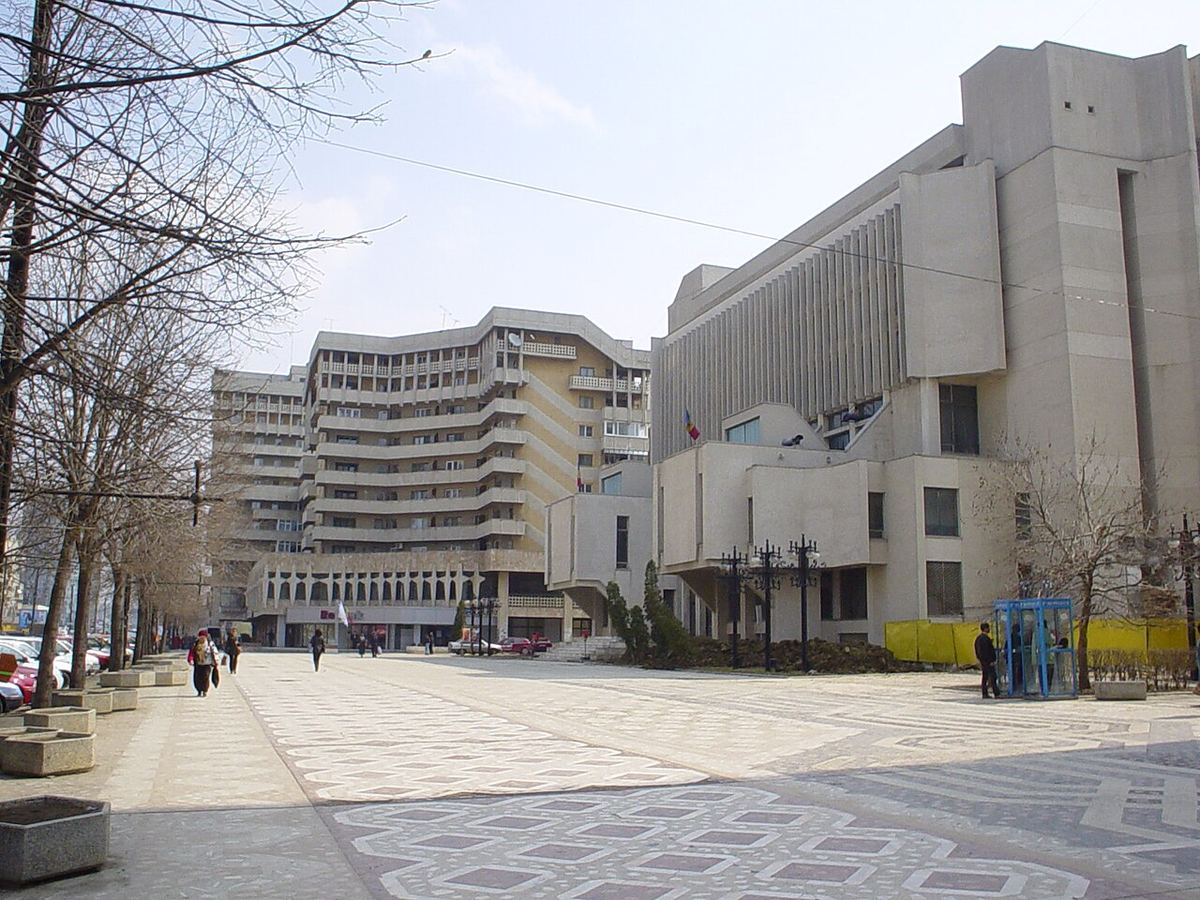 Fațada clădirii Tribunalului Iași, cu piața pietonală din față, pe o zi cu cer senin.