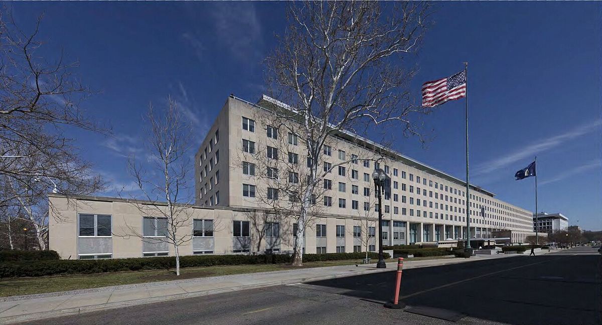 Clădirea Departamentului de Stat al SUA din Washington D.C., cu steagul american fluturând pe catarg.