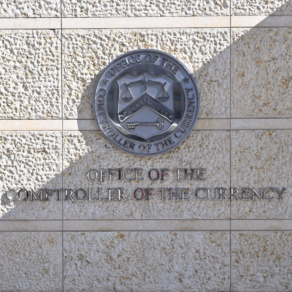 Sigla Oficiului Controlorului Monedei (OCC) pe peretele clădirii sediului din Washington, DC, Statele Unite.
