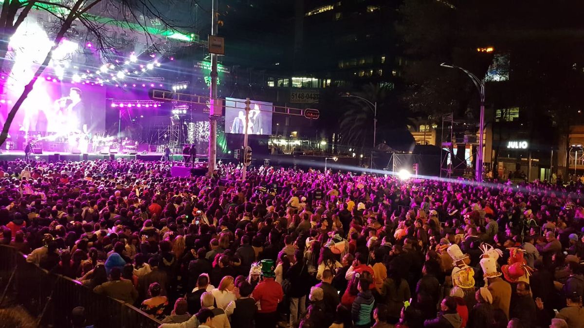 Public numeros în fața unei scene de concert, seara