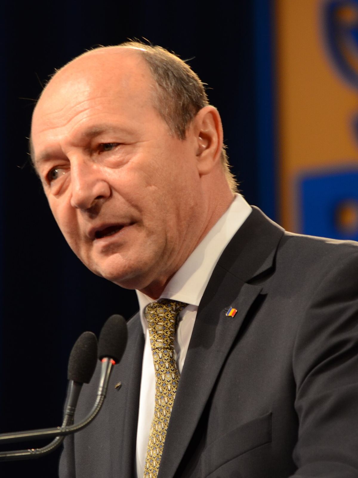 Traian Băsescu vorbind la un microfon, în fața unui fundal albastru și galben, la Convenția PD-L din 2013 (fotografie de arhivă).