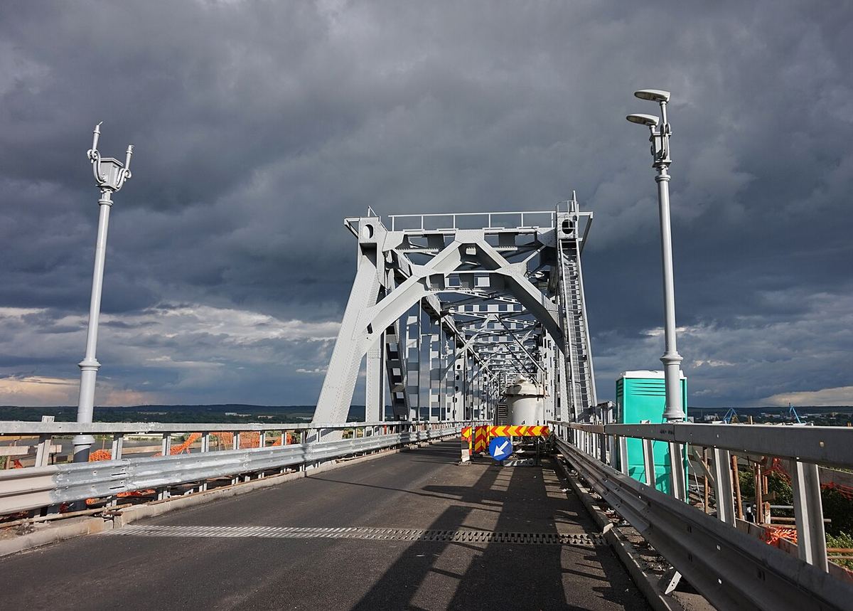 Podul Giurgiu–Ruse (Podul Prieteniei) văzut de pe accesul românesc, cu carosabilul, bariere și structura metalică albă sub nori.