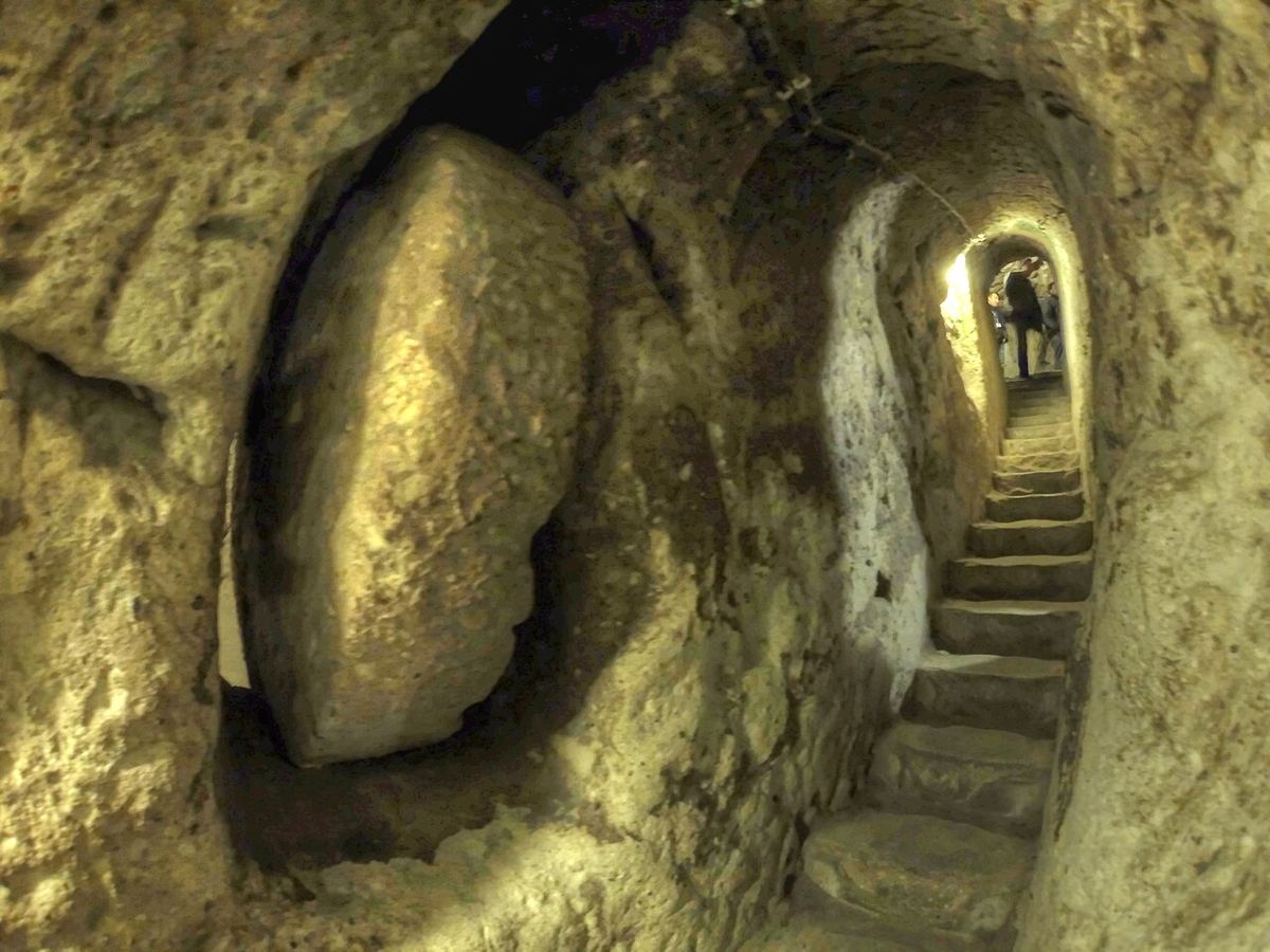 Tunel săpat în piatră cu trepte în orașul subteran Derinkuyu, Cappadocia, cu pereți de tuf vulcanic.