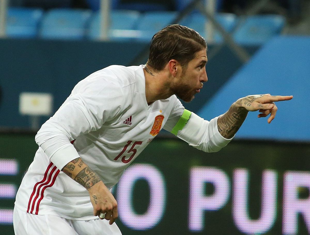 Sergio Ramos în tricoul echipei naționale a Spaniei, cu banderola de căpitan, arătând spre dreapta. Fotografie de arhivă.