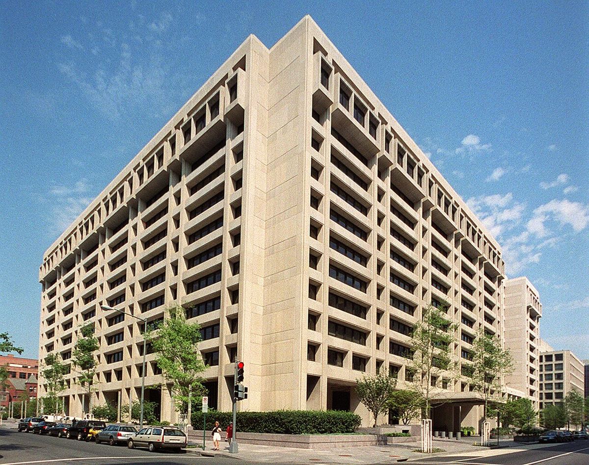 Clădirea sediului FMI din Washington, DC, vedere exterioară cu fațada din beton și trafic pe stradă.