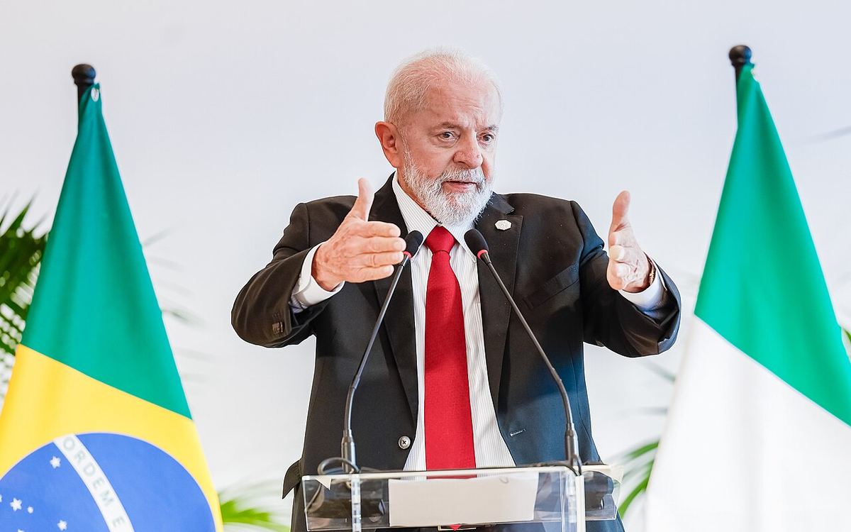 Luiz Inácio Lula da Silva vorbind la un pupitru cu microfoane, în fața steagurilor Braziliei și Italiei (fotografie de arhivă, 2024).