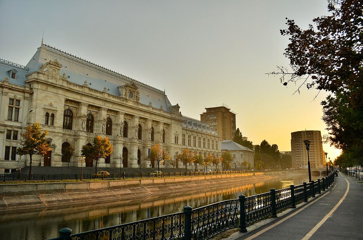 Palatul Justiției din București, fotografiat la apus, pe malul opus al râului Dâmbovița.