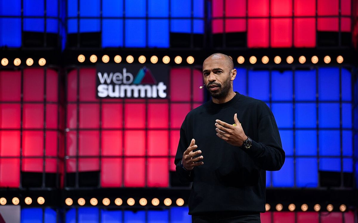 Thierry Henry vorbind pe scena Web Summit, în fața unui fundal roșu și albastru (fotografie de arhivă, 2021).