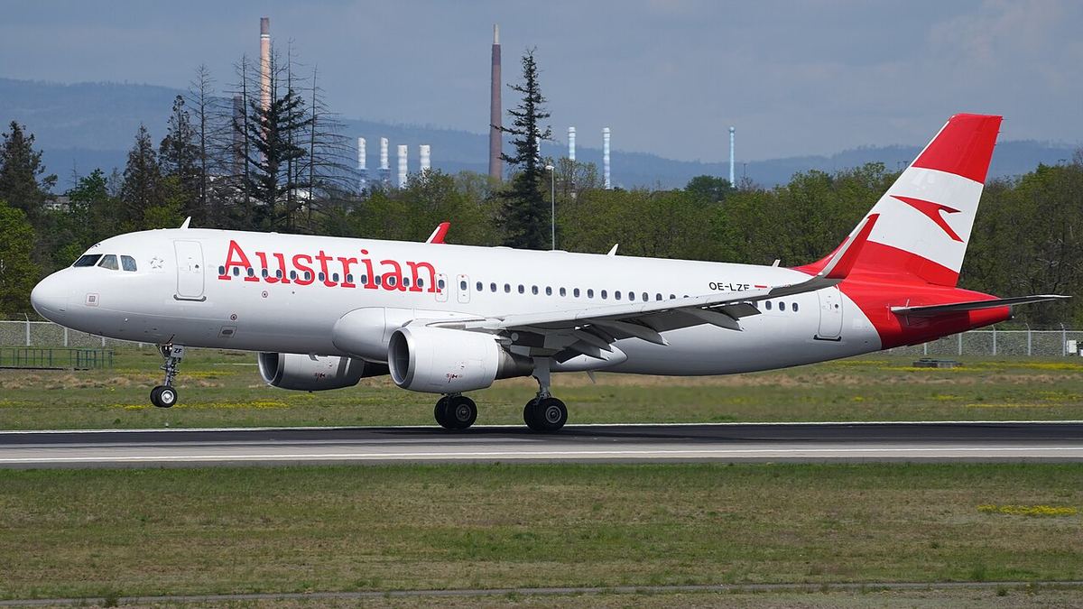 Avion Airbus A320 Austrian Airlines cu livrea roșu-alb aterizând pe pista unui aeroport (imagine de arhivă).