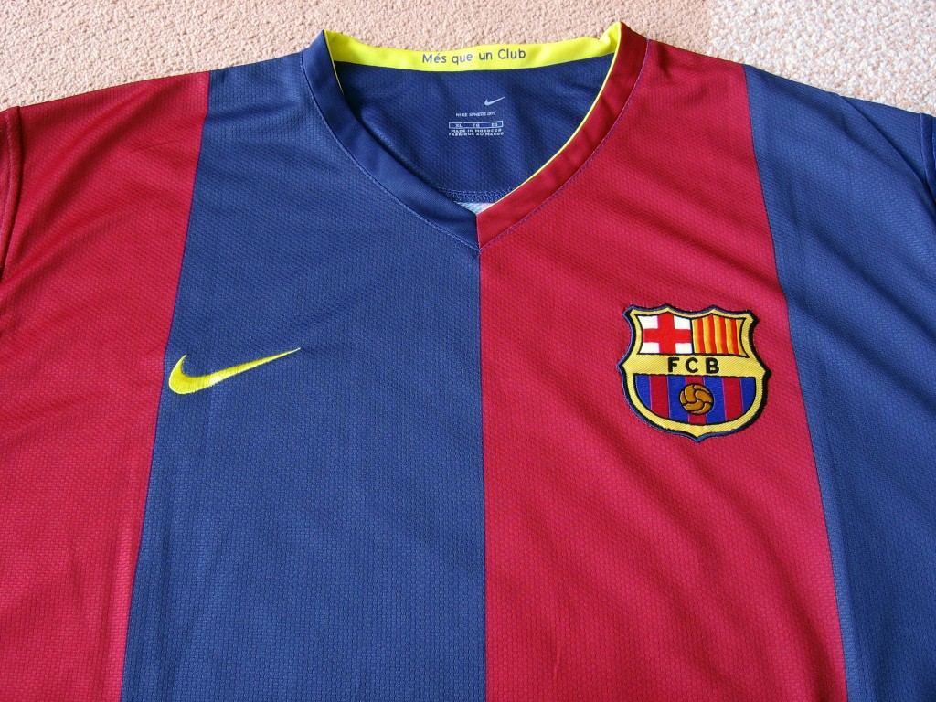 Tricou de acasă al FC Barcelona, cu dungi albastre și granat, emblema clubului și logo-ul Nike.