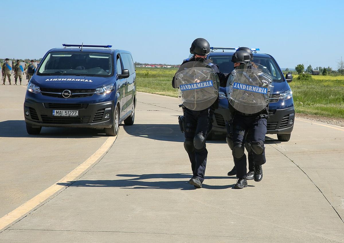 Jandarmi cu scuturi lângă autospeciale ale Jandarmeriei Române